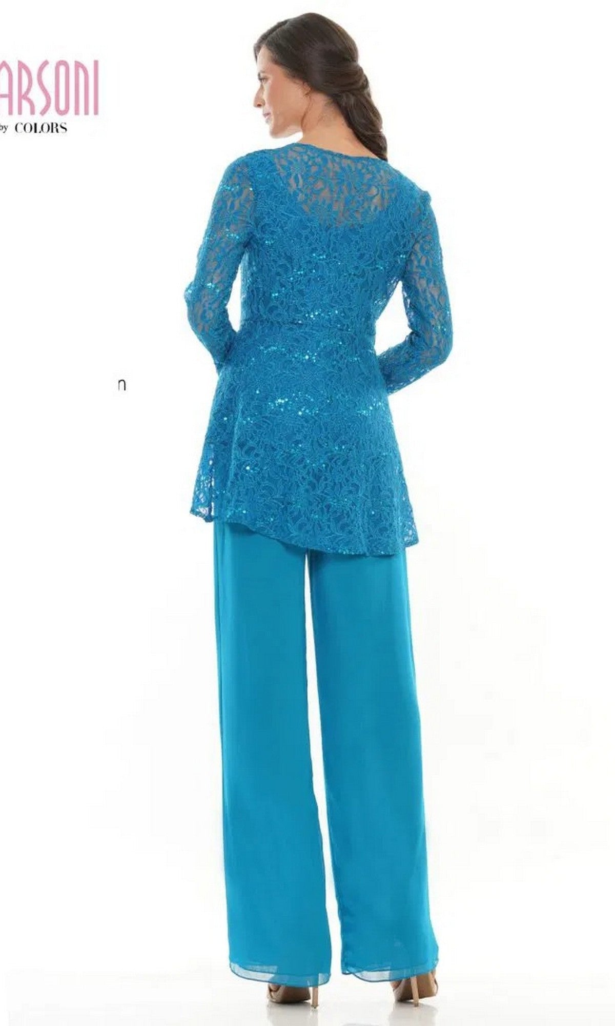 A woman stands facing away from the camera, wearing the Marsoni M305 long formal pantsuit featuring a blue lace jacket with long sleeves and matching chiffon pants.